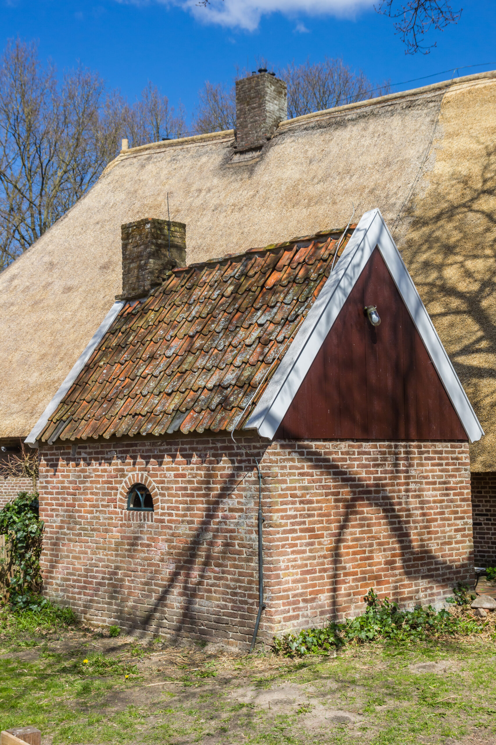 Little brick shed in front of a historic house in Orvelte, Netherlands